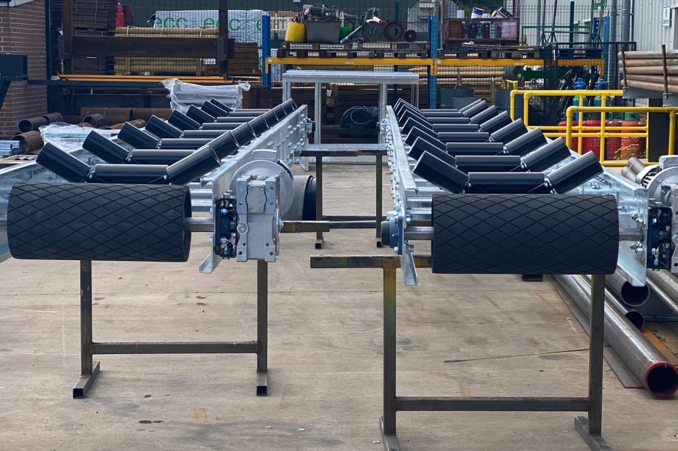 Metal processing equipment with a series of cylindrical rollers mounted on a steel frame.